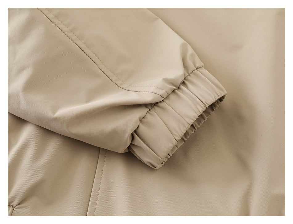 Close-up of a beige garment sleeve with a gathered elastic cuff and visible stitching.