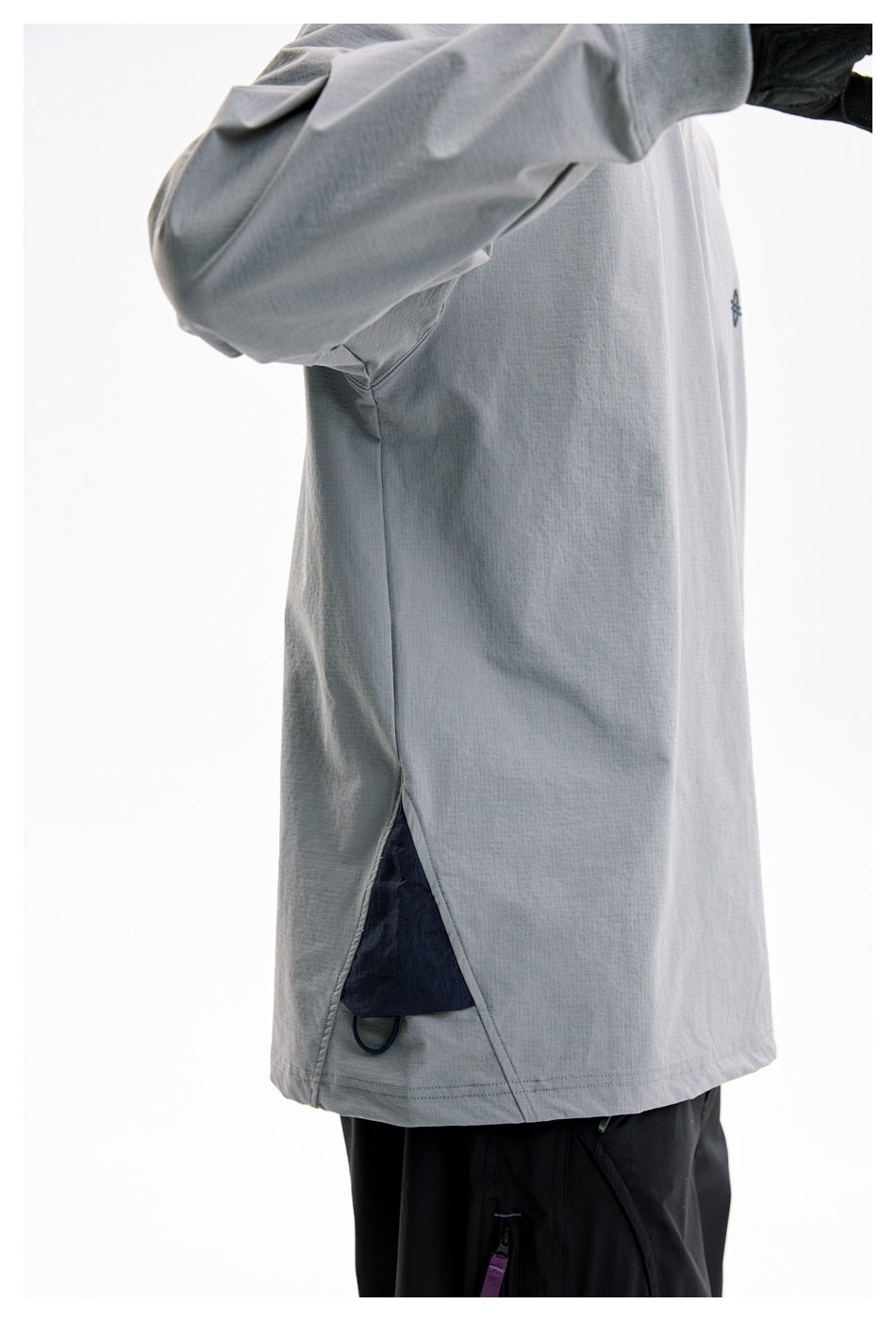 Side view of the gray long-sleeve shirt on a model, showing a lower side slit and dark inner panel.
