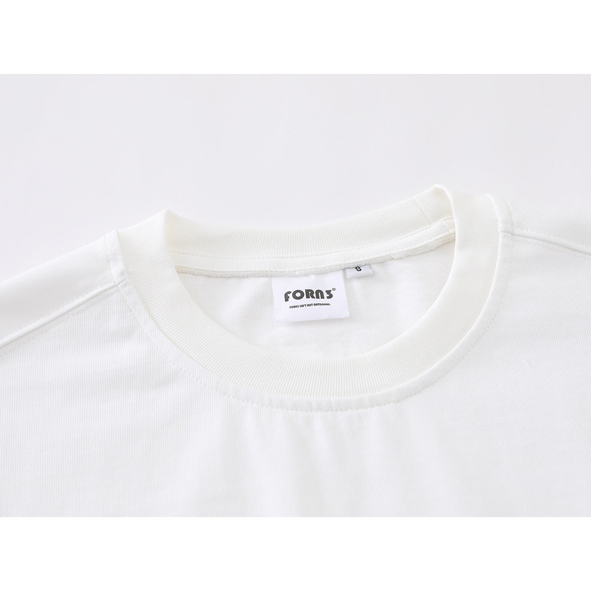 Close-up of a white long-sleeve shirt’s ribbed crew neckline and sewn-in neck label.