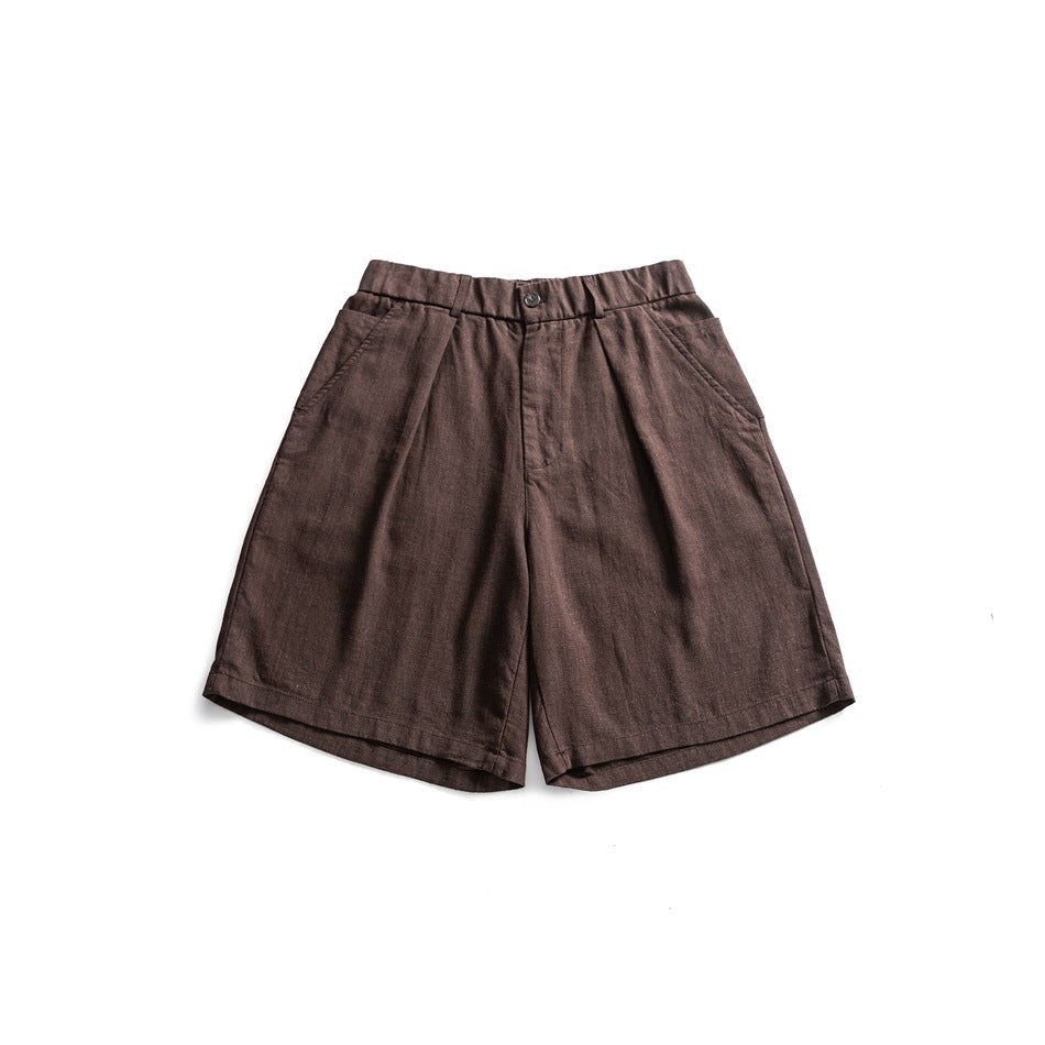 Brown pleated knee-length shorts with elastic waistband and button closure, flat lay front view