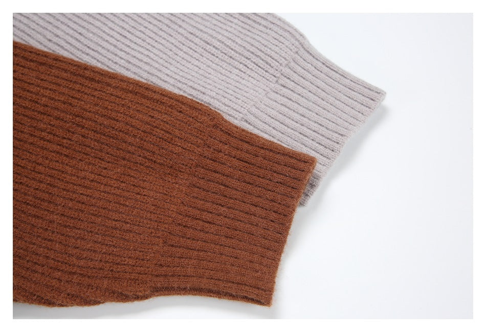 Close-up of ribbed cardigan cuffs in rust brown and light gray.