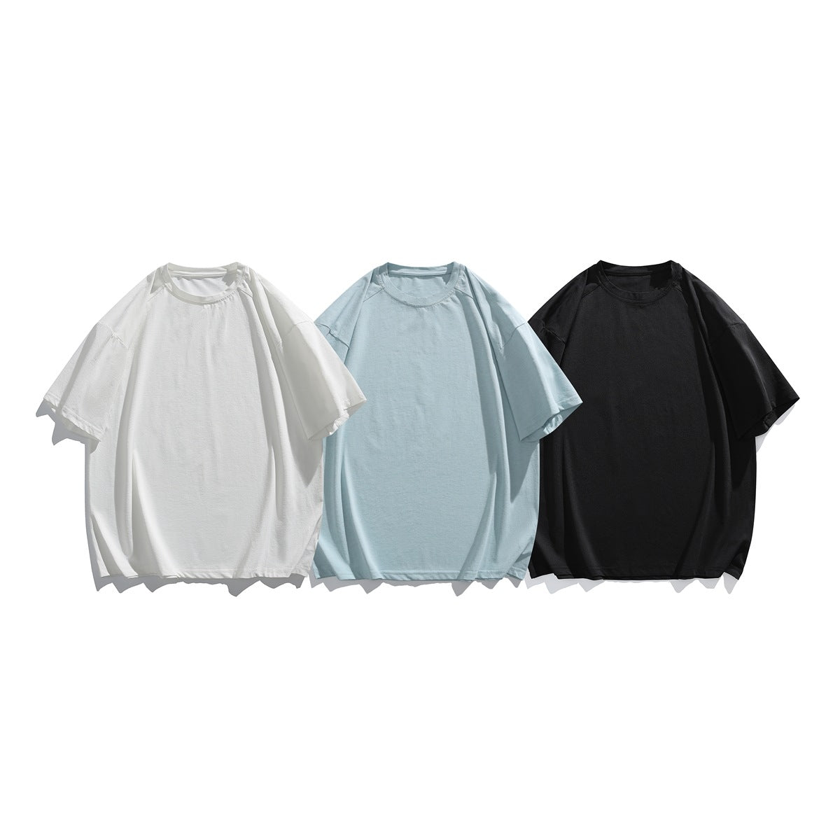 Three plain short-sleeve crew-neck T-shirts shown in white, pale blue, and black.