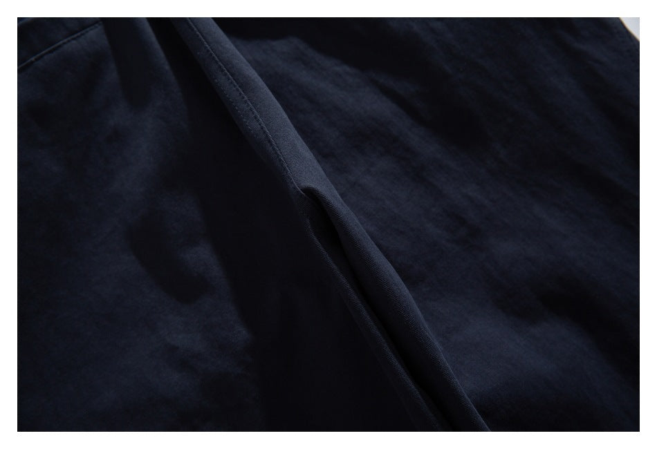 Close-up of dark navy garment fabric with a raised seam and soft folds.