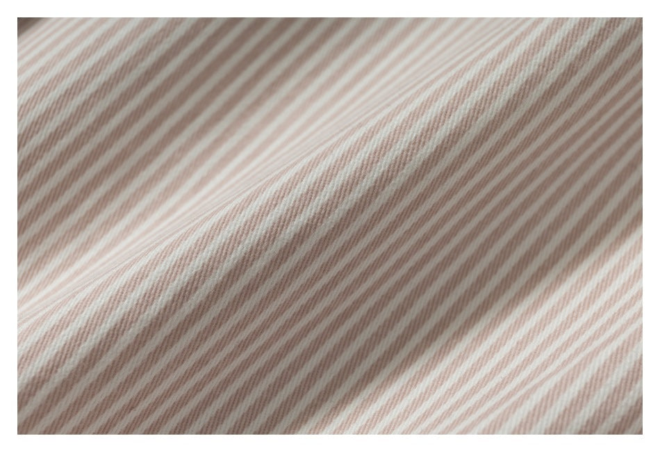 Close-up of pink-and-white striped fabric showing its fine ribbed texture and folds.