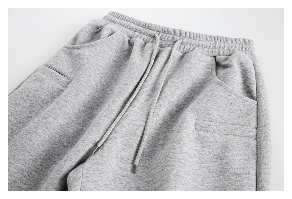 Close-up of heather gray pants showing the elastic waist, drawstring, and front pockets.