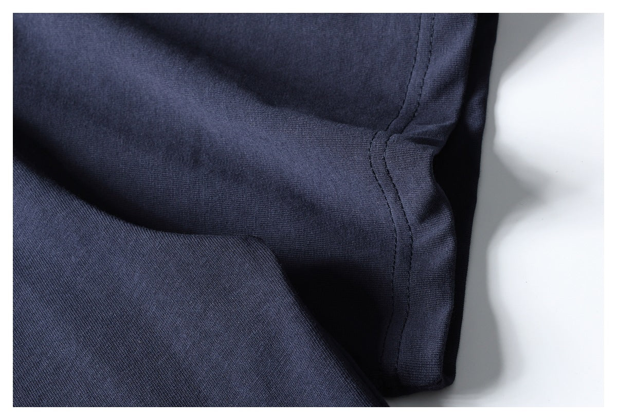 Close-up of navy garment seam stitching and folded fabric edge.