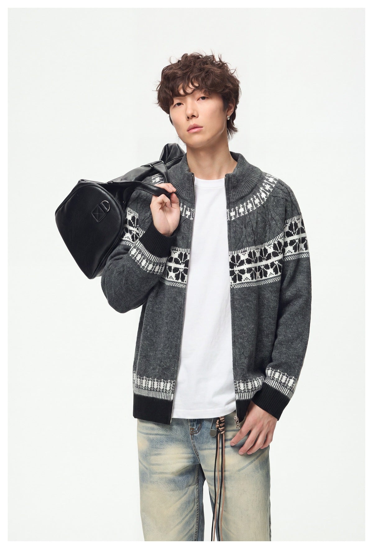 Model wearing an open charcoal full-zip cardigan with a high collar, cable-knit details and white patterned bands.