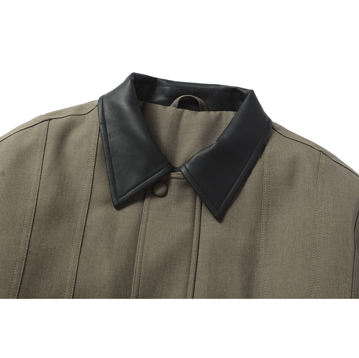 Close-up of an olive jacket's black pointed collar and vertical stitched panels.