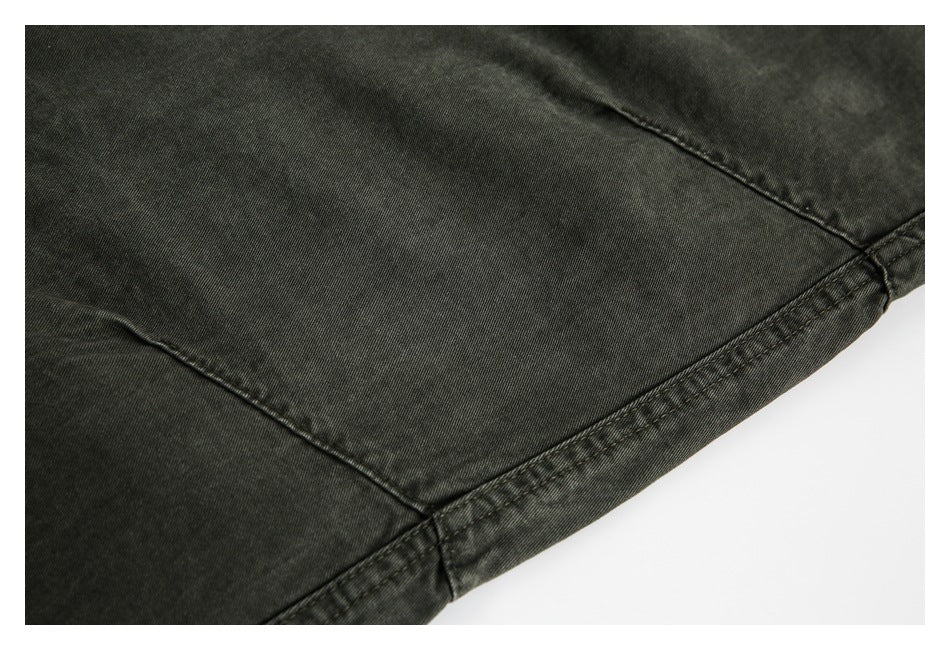 Close-up of dark charcoal garment fabric with curved seam stitching and a finished edge.