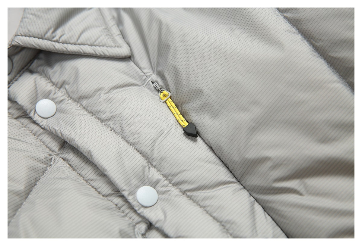 Close-up of the gray pinstriped jacket's snap-button placket and yellow zipper pull.