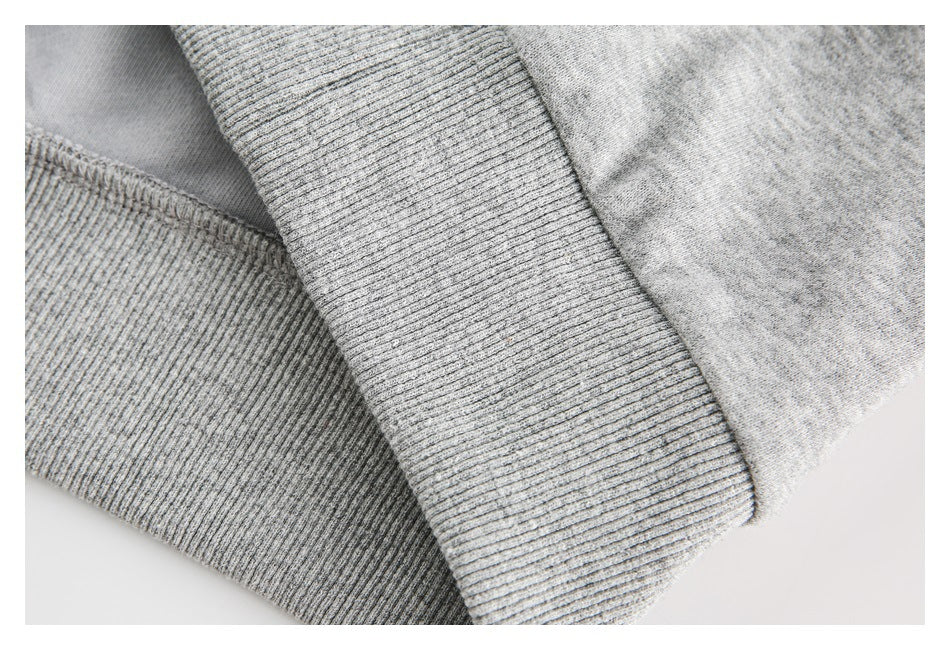 Close-up of the gray top's ribbed cuff and stitched seam.