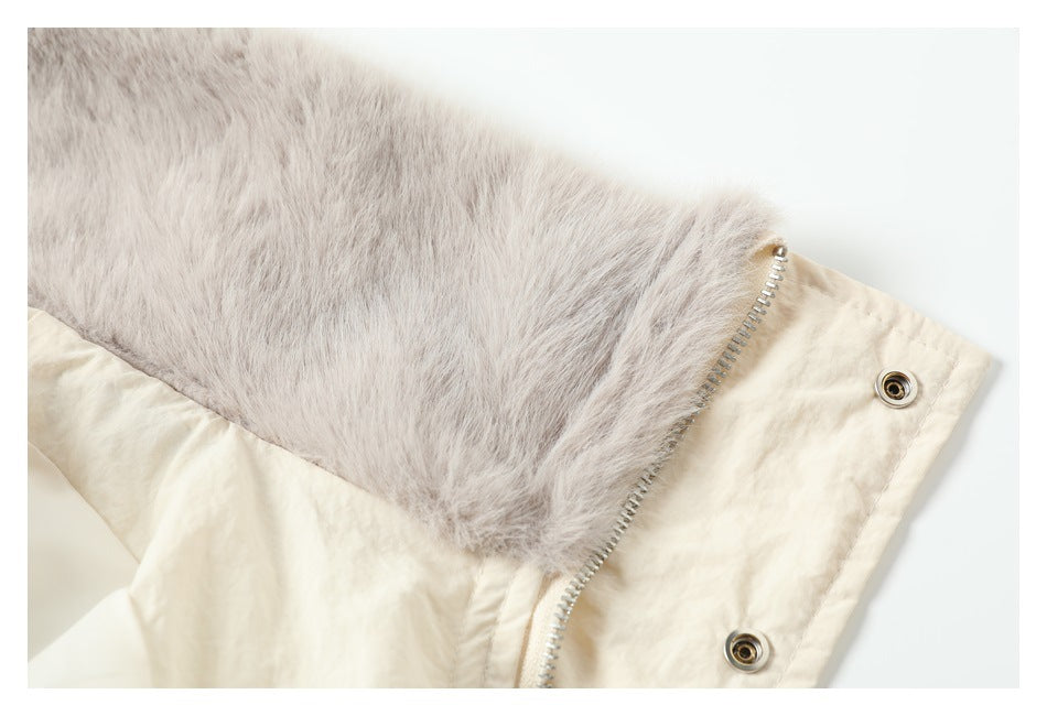 Close-up of plush gray-beige lining attached to a cream garment beside a metal zipper and snap fasteners.
