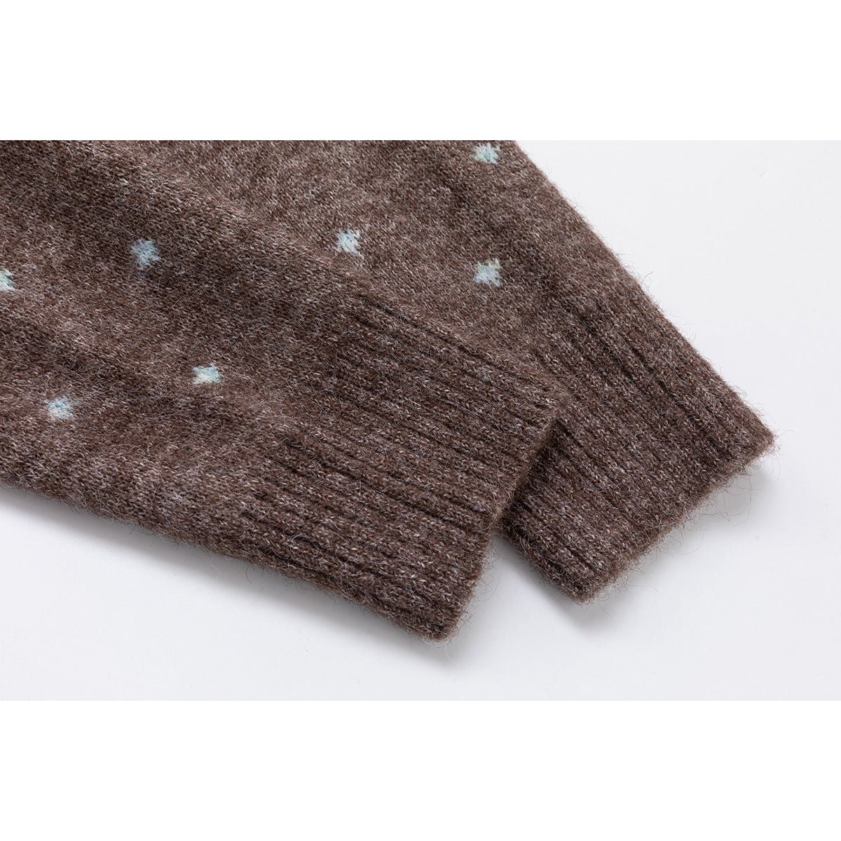 Close-up of the ribbed cuffs on a brown knit sweater with small pale blue dots.