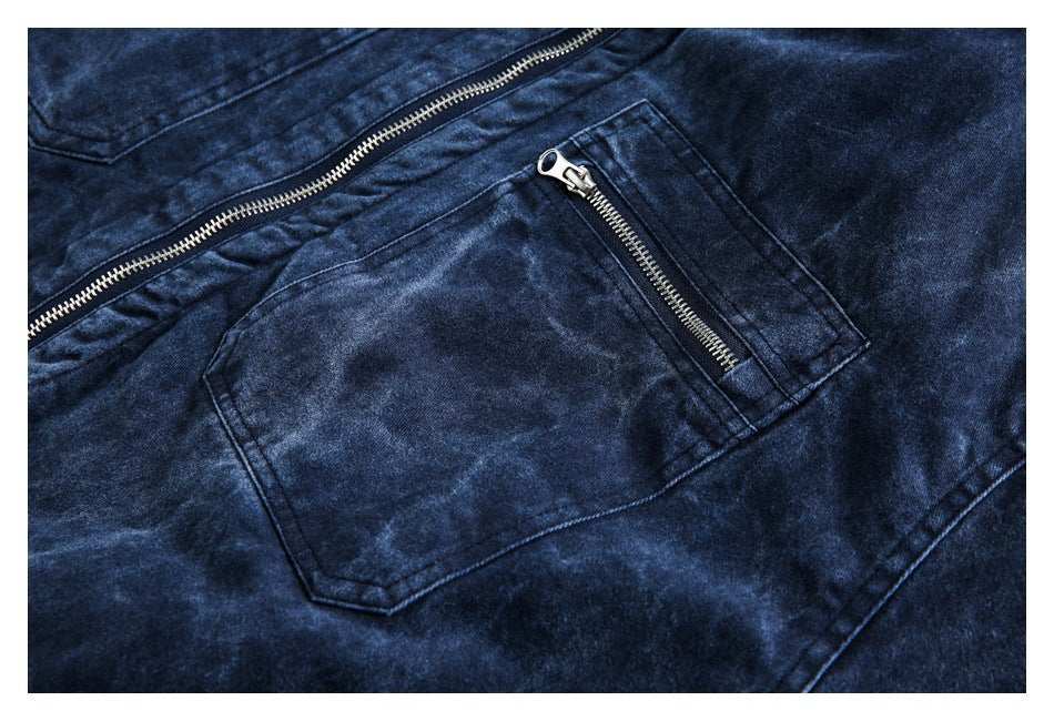 Close-up of a dark blue washed jacket pocket with a silver zipper and part of the front closure.