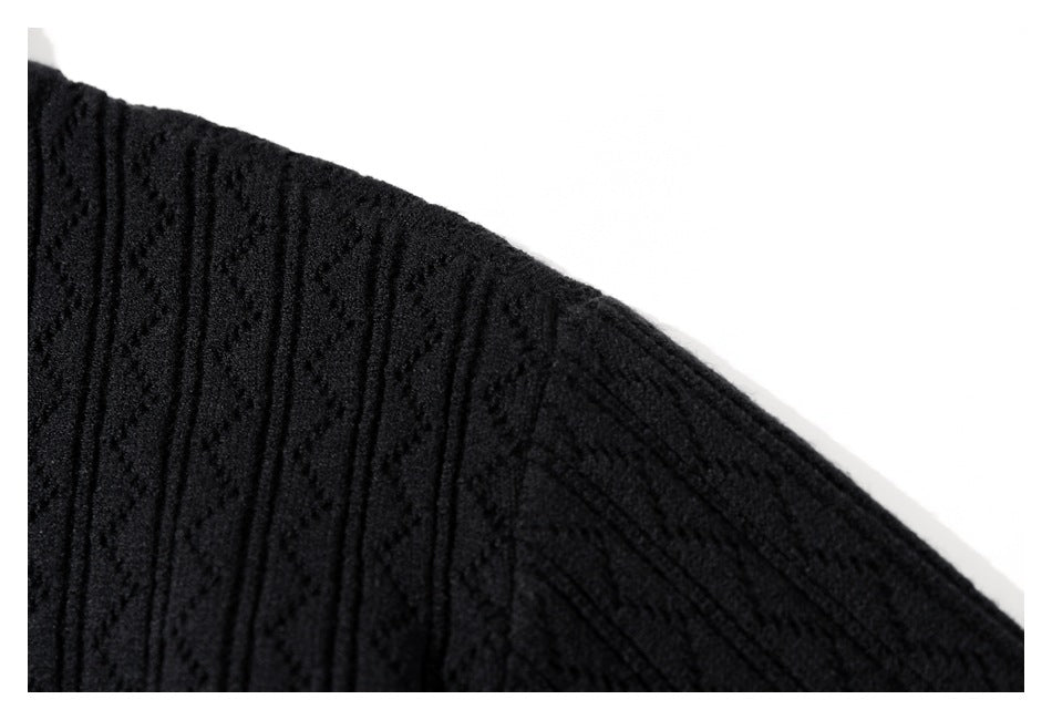 Close-up of black textured knit fabric along a curved garment edge.