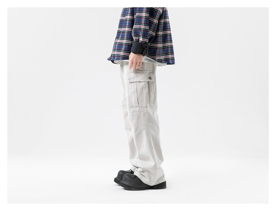 Side view of a model wearing beige cargo pants with a button-flap cargo pocket and plaid shirt