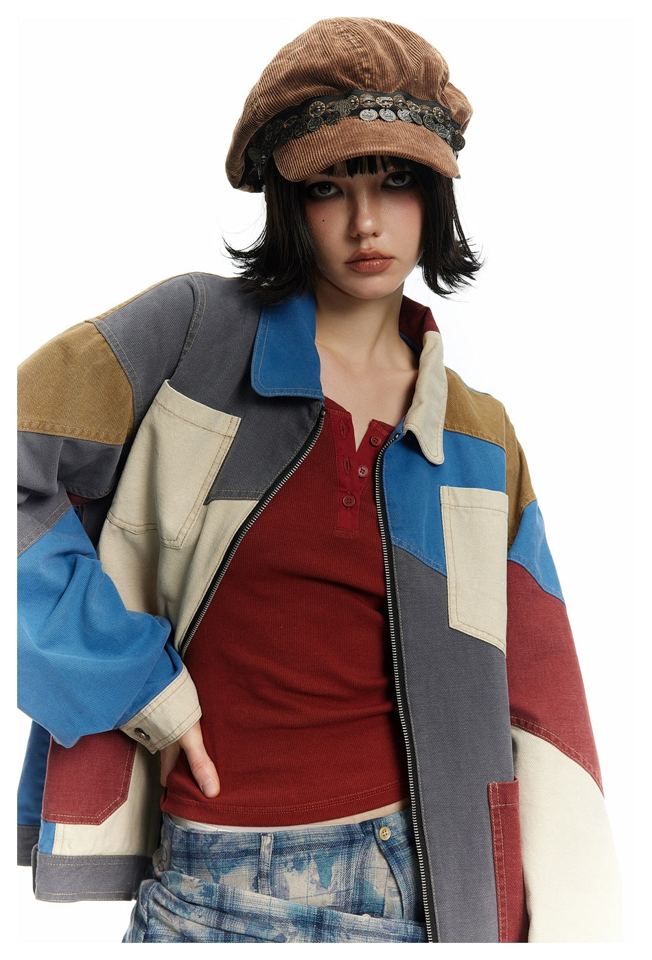 Close view of the jacket’s blue, charcoal, burgundy, tan, and cream panels, collar, zipper, and chest pockets.