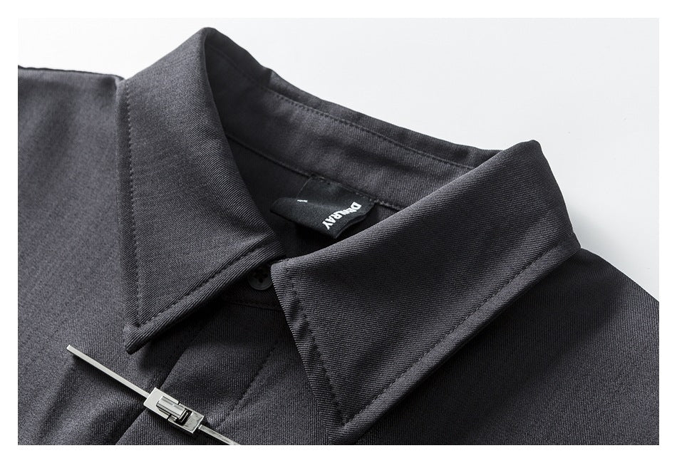 Close-up of the charcoal shirt's pointed collar, neckline, sewn label, and a metal front fastener.