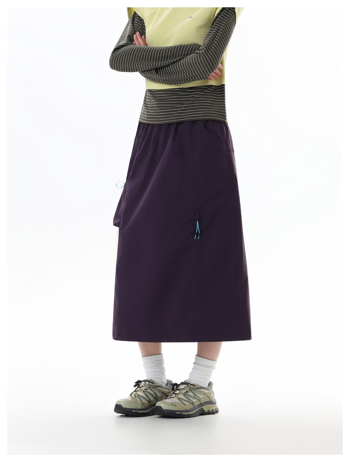 Model wearing a dark plum midi skirt with a side pocket and turquoise drawcord detail, shown from the front.