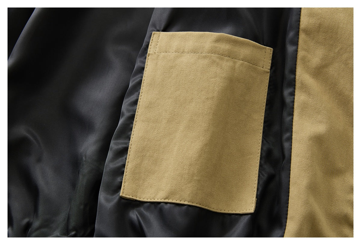 Close-up of a tan rectangular pocket stitched onto black lining.