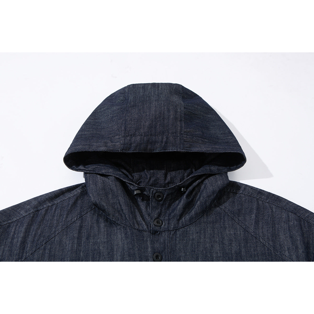 Close-up of a dark indigo hood and buttoned neckline on a pullover jacket.