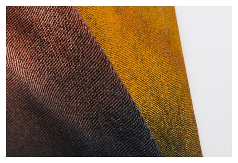 Close-up showing the diagonal twill texture and contrasting rust, charcoal and mustard fabric colors.