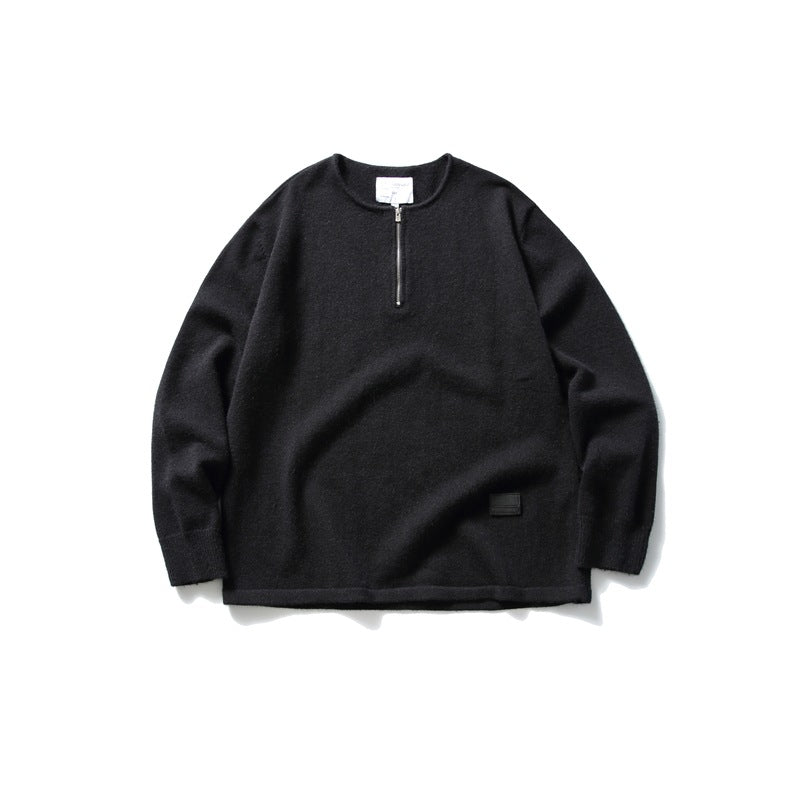 Black knit half-zip pullover sweater with round neck and small black patch at the hem, flat lay front view