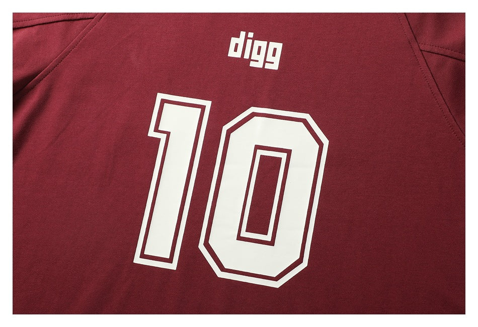 Close-up of a burgundy shirt with a white “digg” print above a large outlined number 10.