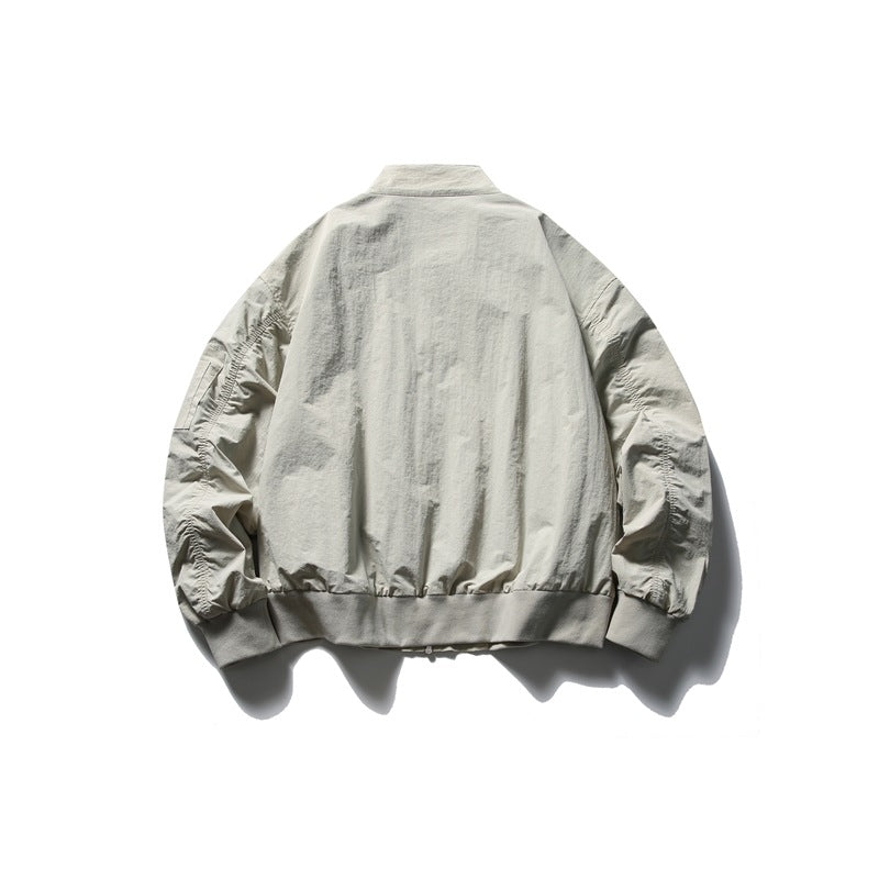 Back view of a light gray-beige zip jacket with a stand collar, gathered sleeves and ribbed hem and cuffs.