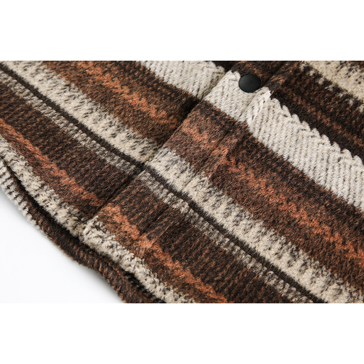 Close-up of the fuzzy brown, cream, and rust plaid fabric and a black snap on the overshirt.