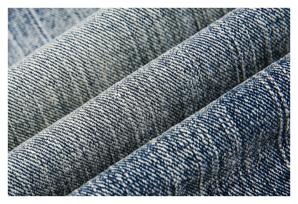 Macro view of the diagonal weave and faded texture of blue denim fabric.