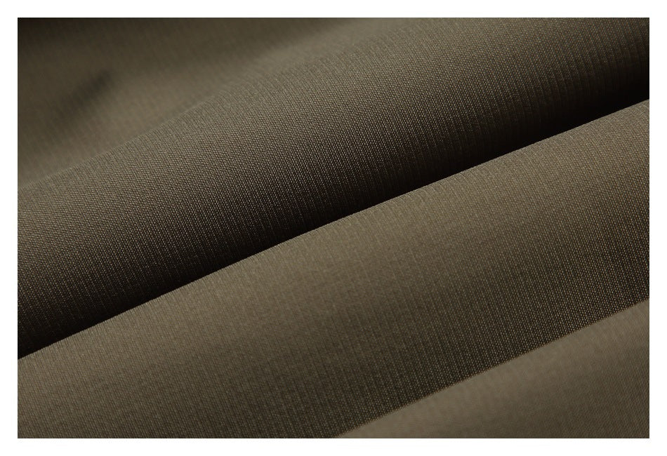 Close-up of olive-brown garment fabric folded to show its fine surface texture.