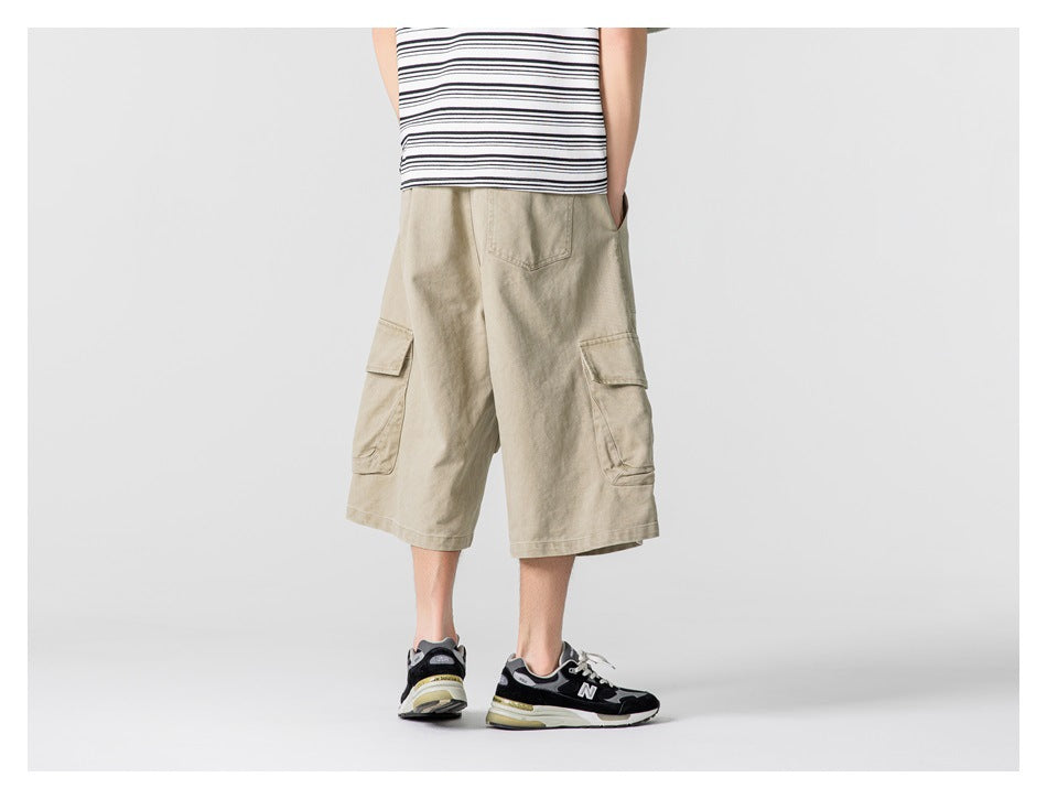 Back view of a model wearing light beige knee-length cargo shorts with side cargo pockets.