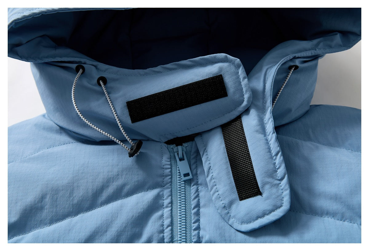 Close-up of a light blue jacket hood's drawcords, hook-and-loop tabs, and front zipper.