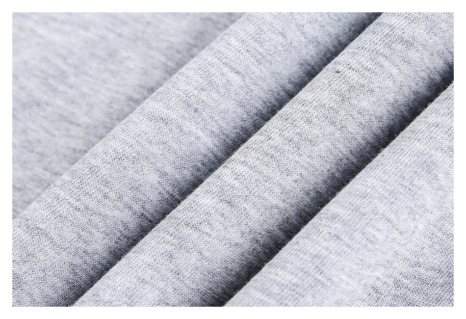 Macro view of light heather gray knit fabric draped in soft folds.