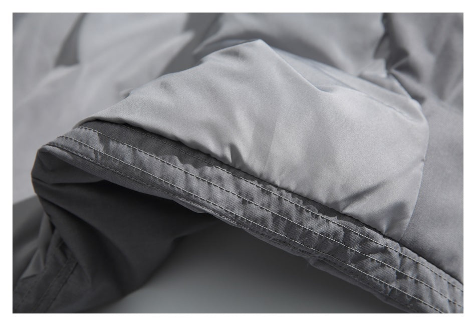 Close-up of a gray jacket edge with folded fabric and parallel rows of stitching.
