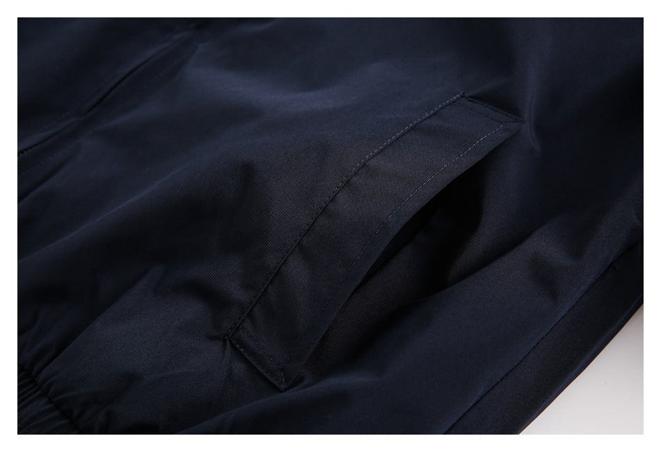 Close-up of a slanted welt pocket on dark navy trousers.