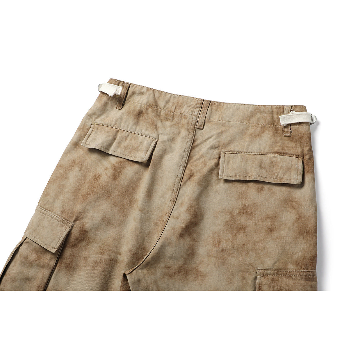 Cropped rear view of tan mottled cargo shorts, showing two flap pockets and side waist adjusters.