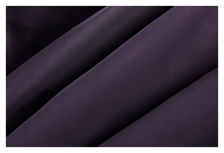 Close-up of dark plum fabric arranged in diagonal folds, showing a fine, even texture.