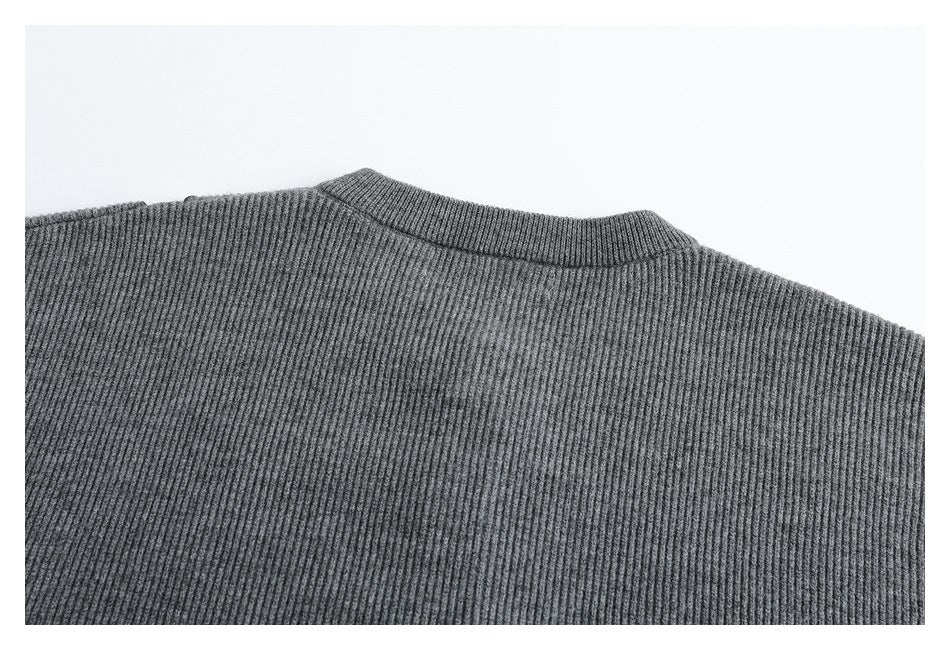 Close-up of a gray rib-knit garment showing the neckline and shoulder seam.