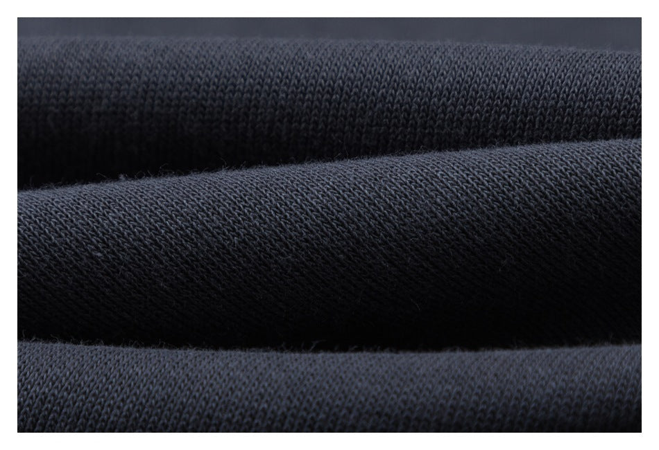Extreme close-up of dark charcoal garment fabric showing its knit texture.