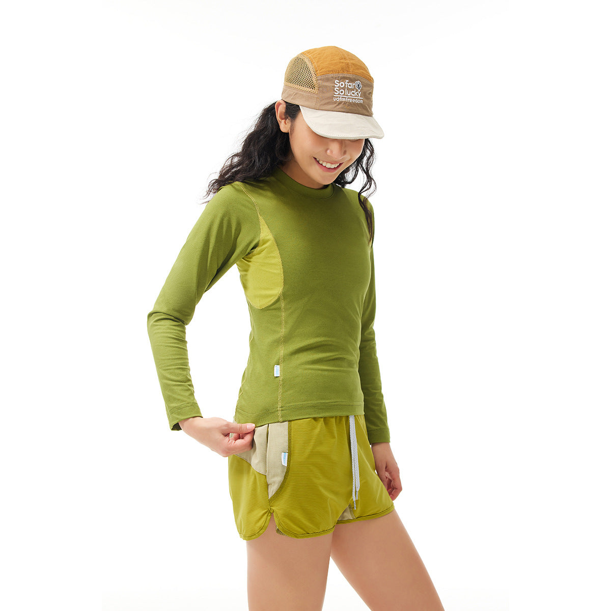 Model wearing an olive green long-sleeve top and matching shorts with contrasting side panels.