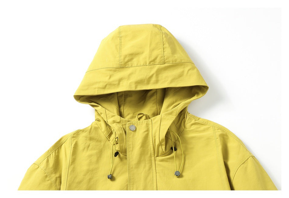 Close-up of a yellow hooded jacket showing the hood, front placket, metal snap, and adjustable drawcords.