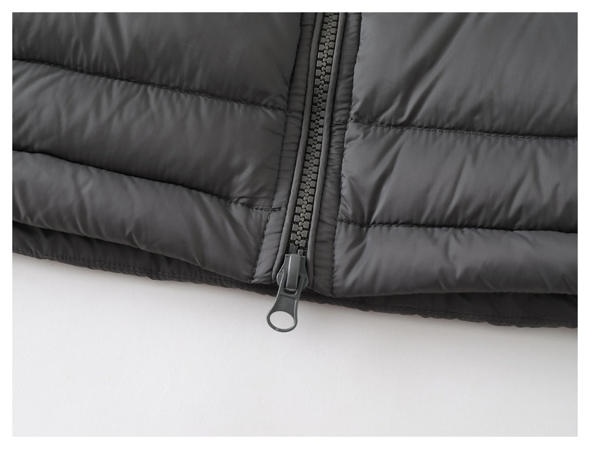 Close-up of the charcoal jacket's lower hem and zipper pull against a white background.