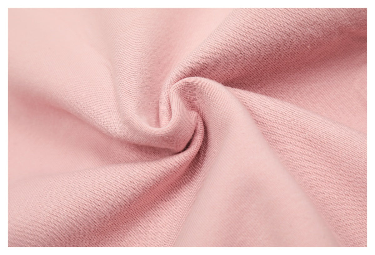 Close-up of pink knit fabric gathered into a swirl, showing the fabric texture.
