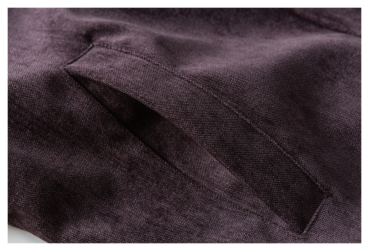 Close-up of a diagonal welt pocket on plum textured fabric.