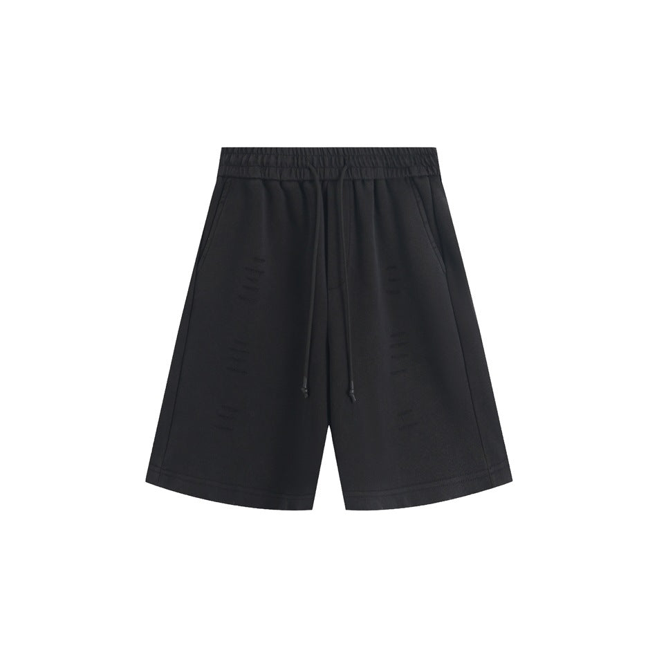 Black knee-length drawstring shorts with elastic waistband, side pockets and small distressed slashes, front view