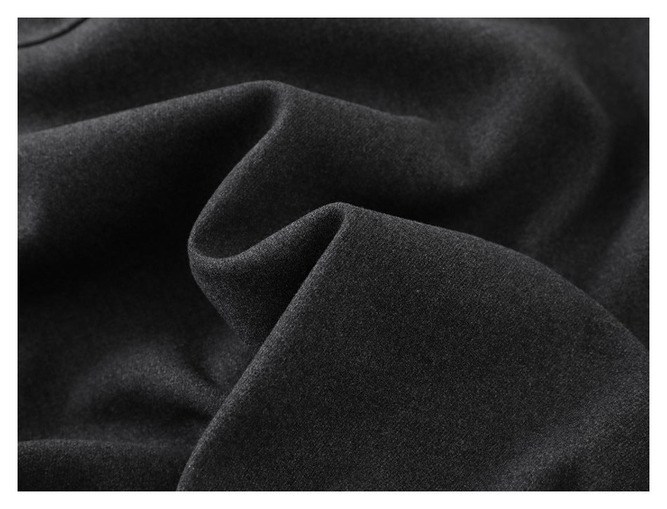 Extreme close-up of the charcoal coat fabric draped in soft folds.