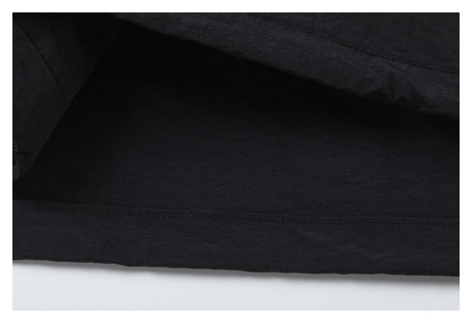Close-up of the black garment's interior and stitched lower hem.
