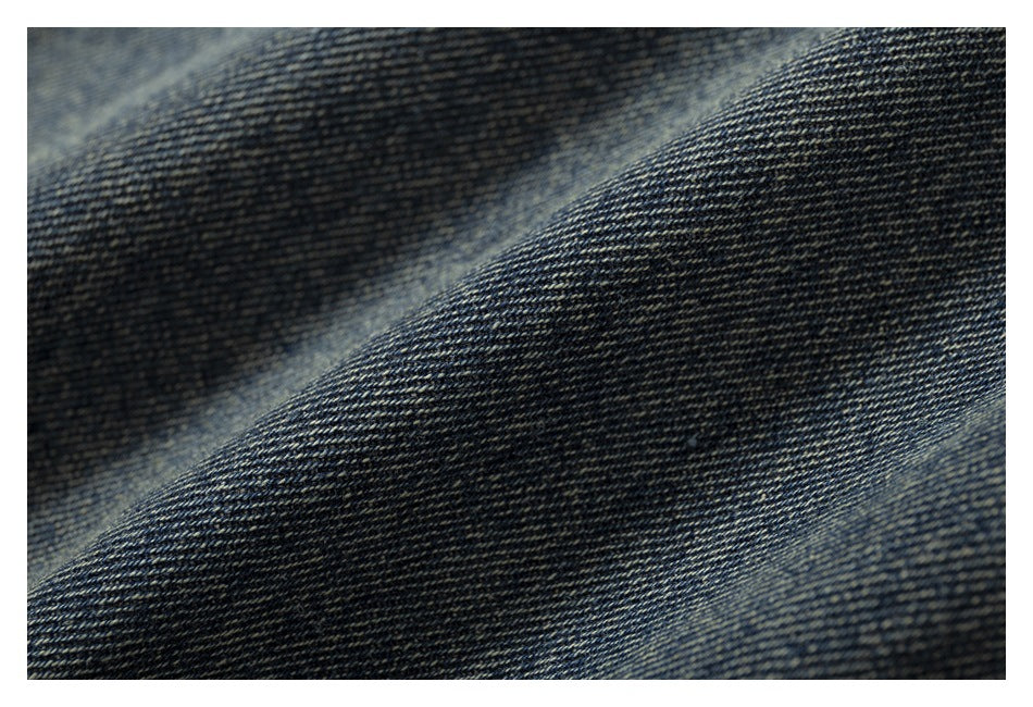 Macro view of dark blue denim twill with diagonal woven texture.